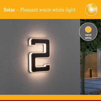 Solar-powered house number 2 with warm white light on grey wall for outdoor use