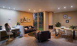 Wohnzimmer mit warm- und kaltweißen LED-Downlights in Decke, moderne Beleuchtung für Wohn- und Arbeitsbereich