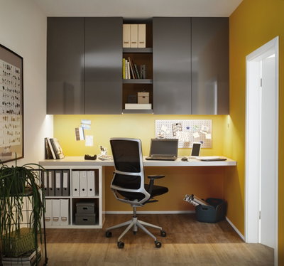 Bureau moderne avec armoires murales grises, mur jaune, chaise de bureau ergonomique et éclairage LED