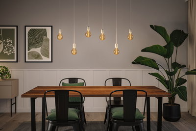 Modern dining area with wooden table, black metal chairs, and warm LED bulb pendant lights