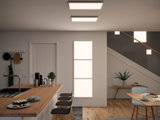 Moderne keuken met houten aanrecht en drie zwarte barkrukken, verlicht door rechthoekige LED-plafondlampen