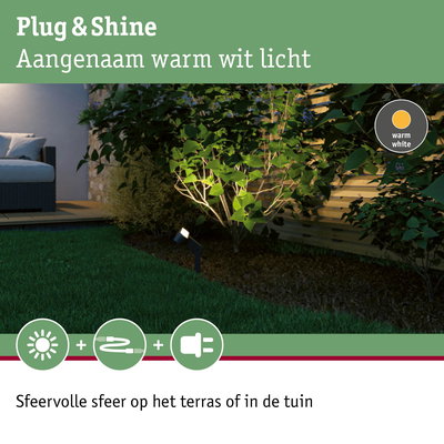 Buitenlamp met warm wit licht verlicht groene planten bij houten schutting in tuin
