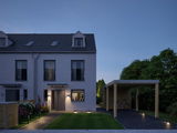 Modern house with grey facade and LED outdoor lighting at entrance and carport in garden at dusk
