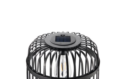 Lampe solaire noire avec cage en métal et ampoule LED visible pour éclairage extérieur.