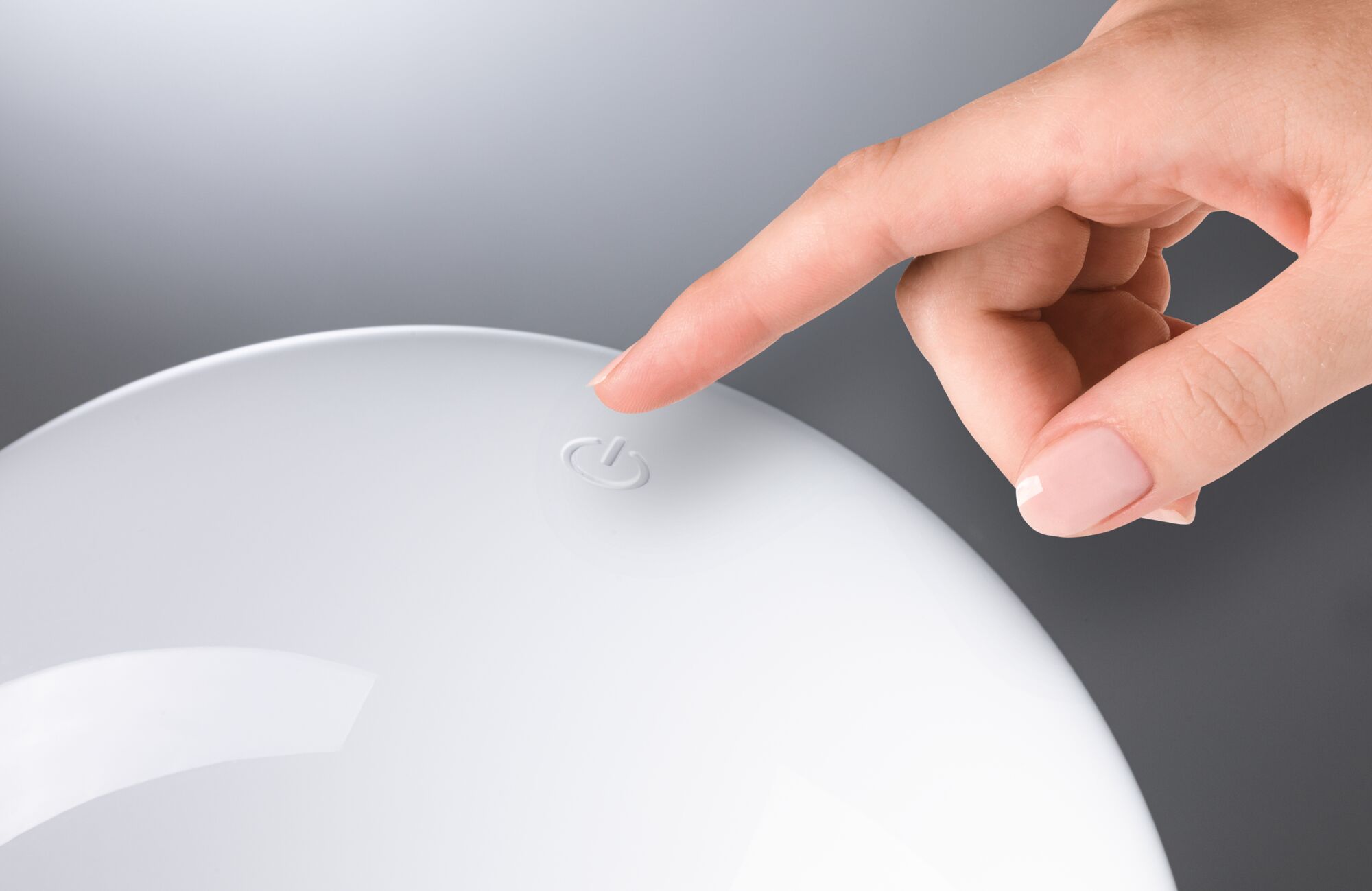 Hand tippt auf weißen Touch-Schalter mit Power-Symbol für moderne LED-Beleuchtung