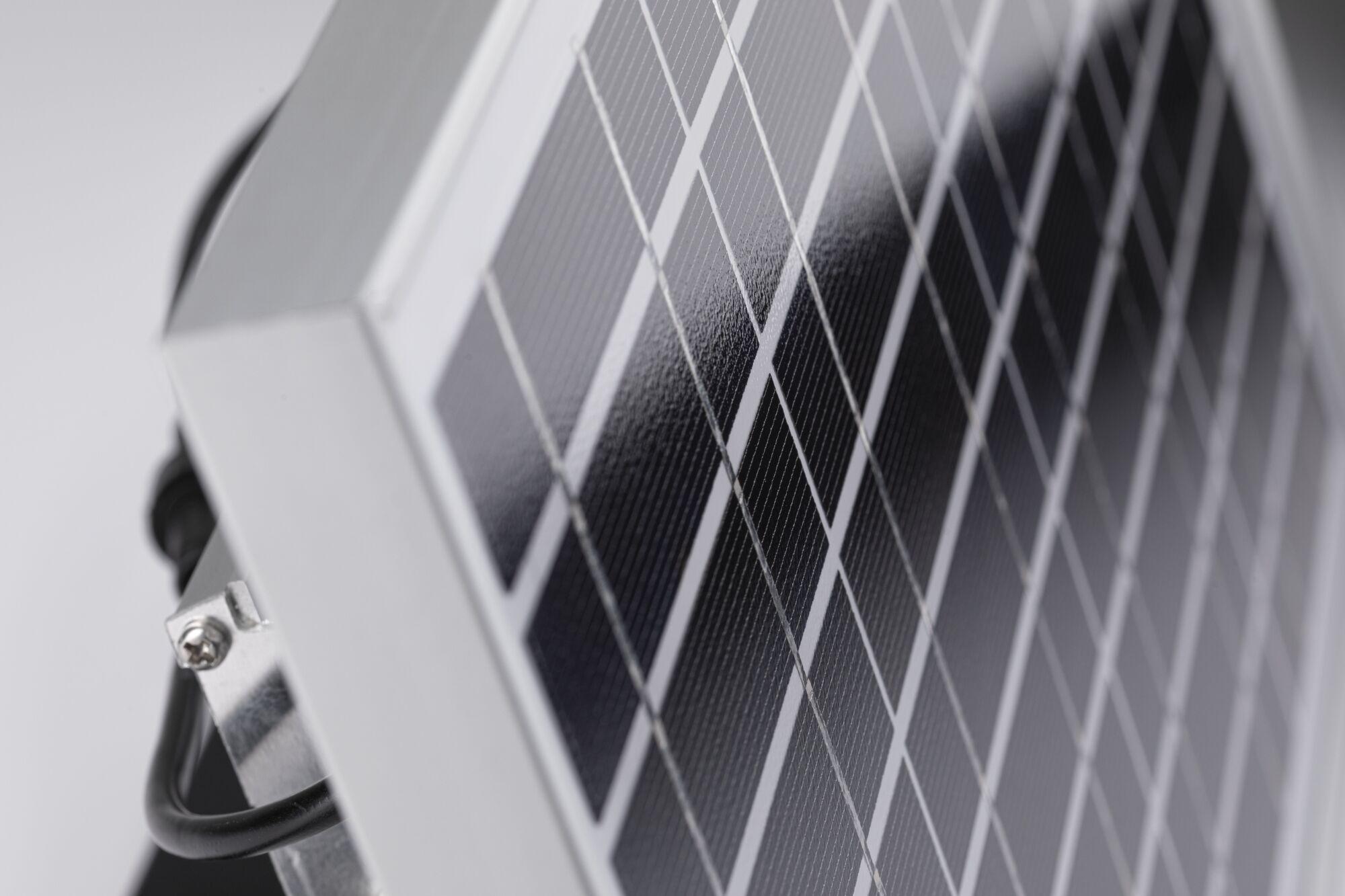 Zbliżenie na czarną panel słoneczny z aluminiową ramą i kablem zasilającym