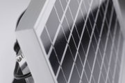 Zbliżenie na czarną panel słoneczny z aluminiową ramą i kablem zasilającym