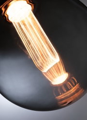 Nahaufnahme einer warm leuchtenden Glühfadenlampe mit klarem Glas für dekorative Beleuchtung