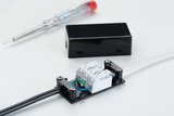 Electrical connection box with black and white cables, screwdriver in background for lighting installation