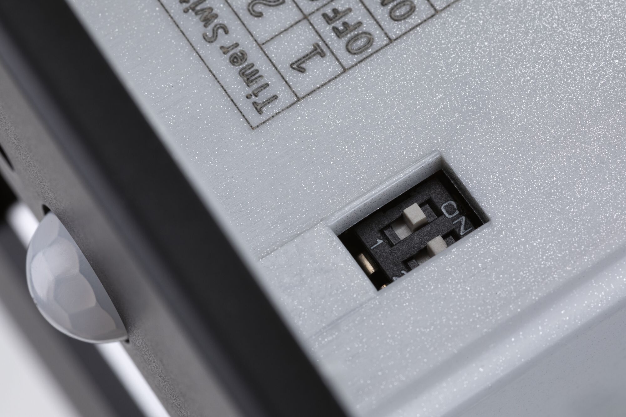 Close-up of white device with black switch and ON/OFF slider for control function.