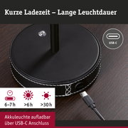 Schwarze Akkuleuchte mit USB-C Anschluss und weißer Naht auf Holztisch, kurze Ladezeit, lange Leuchtdauer