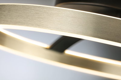 Gros plan sur un anneau LED en aluminium brossé avec lumière blanche chaude pour intérieur moderne