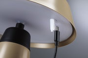 Nahaufnahme eines goldfarbenen Metalllampenschirms mit USB-C-Ladekabelanschluss und schwarzem Kabel