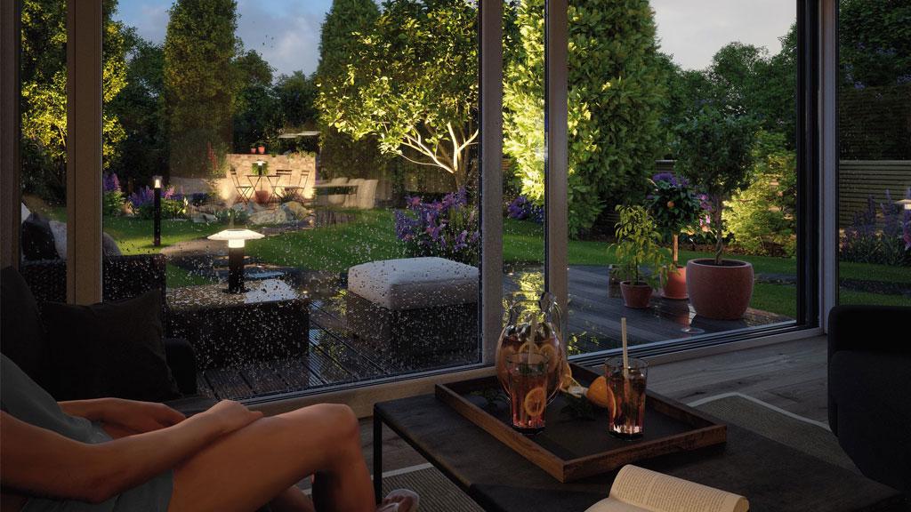 Gemütlicher Innenraum mit Blick auf beleuchteten Garten bei Regen, Outdoor LED-Beleuchtung im Fokus.