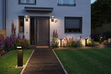 Modern outdoor area with black LED path lights and wall lights on grey house facade.