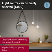 Round wall mirror with black frame and two white pendant lights in modern bathroom with wooden shelf