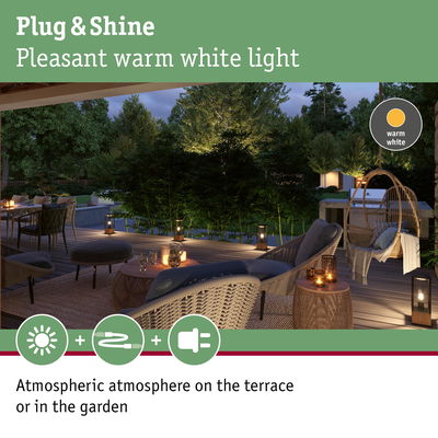 Cozy terrace illuminated by warm white Plug & Shine lights creating atmospheric garden lighting