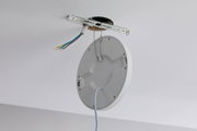 Round white ceiling mount with cables and metal bracket for LED light installation.