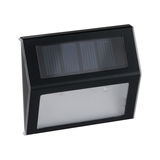 Black solar wall light with transparent plastic diffuser for energy-saving outdoor lighting