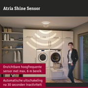 Witte plafondlamp met sensor in moderne wasruimte met wasmachine en droger