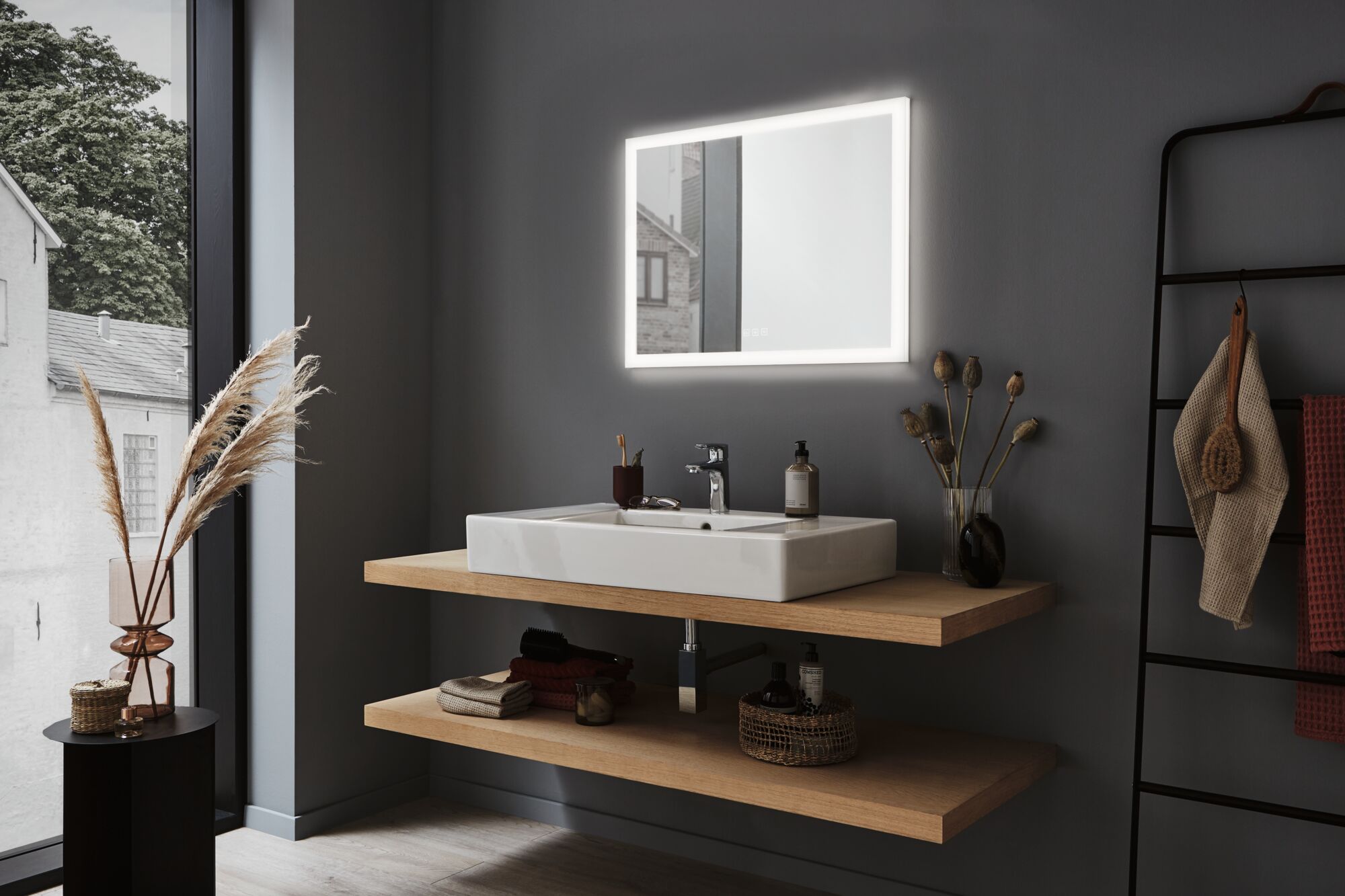 Modernes Badezimmer mit beleuchtetem rechteckigem Spiegel und weißem Keramikwaschbecken auf Holzregal