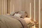 Modernes Schlafzimmer mit Holzlamellenwand und warmweißer LED-Beleuchtung für gemütliche Atmosphäre