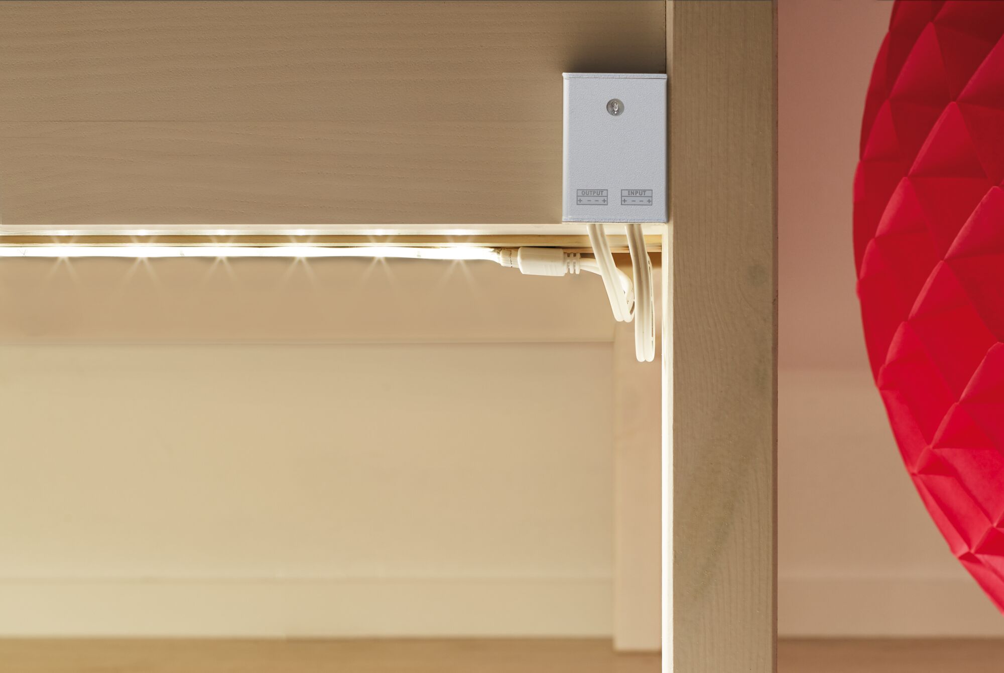 White LED light strip under light wood shelf with cable connection for modern room lighting
