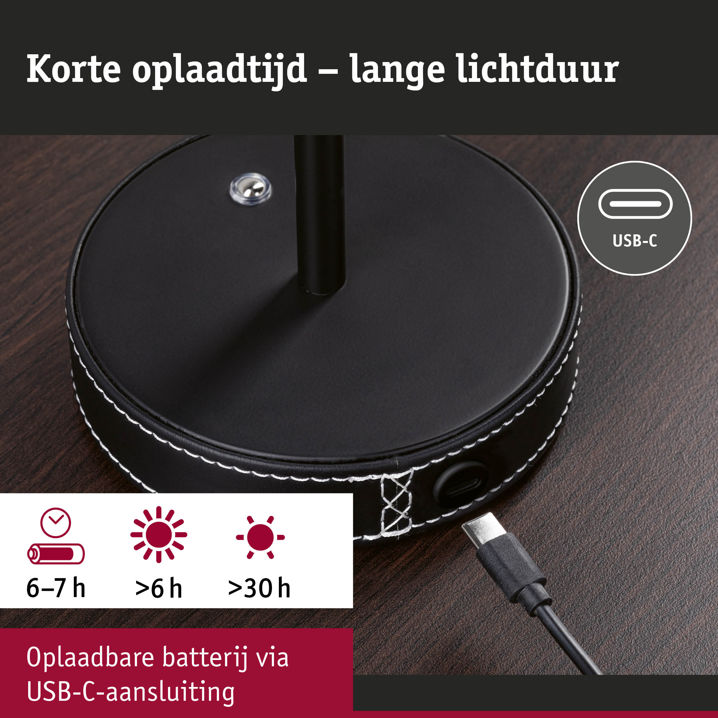 Zwarte ronde oplaadbasis met USB-C aansluiting en witte stiksels op donker houten tafel