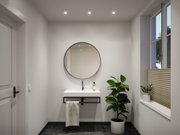 Modernes Badezimmer mit rundem Spiegel, weißem Waschbecken und schwarzem Armatur-Set, Pflanzen und Fenster.