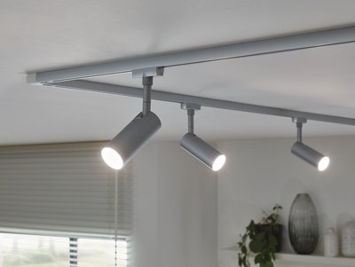 Three silver LED track spotlights on white ceiling for modern home lighting.