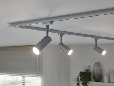 Three silver LED track spotlights on white ceiling for modern home lighting.