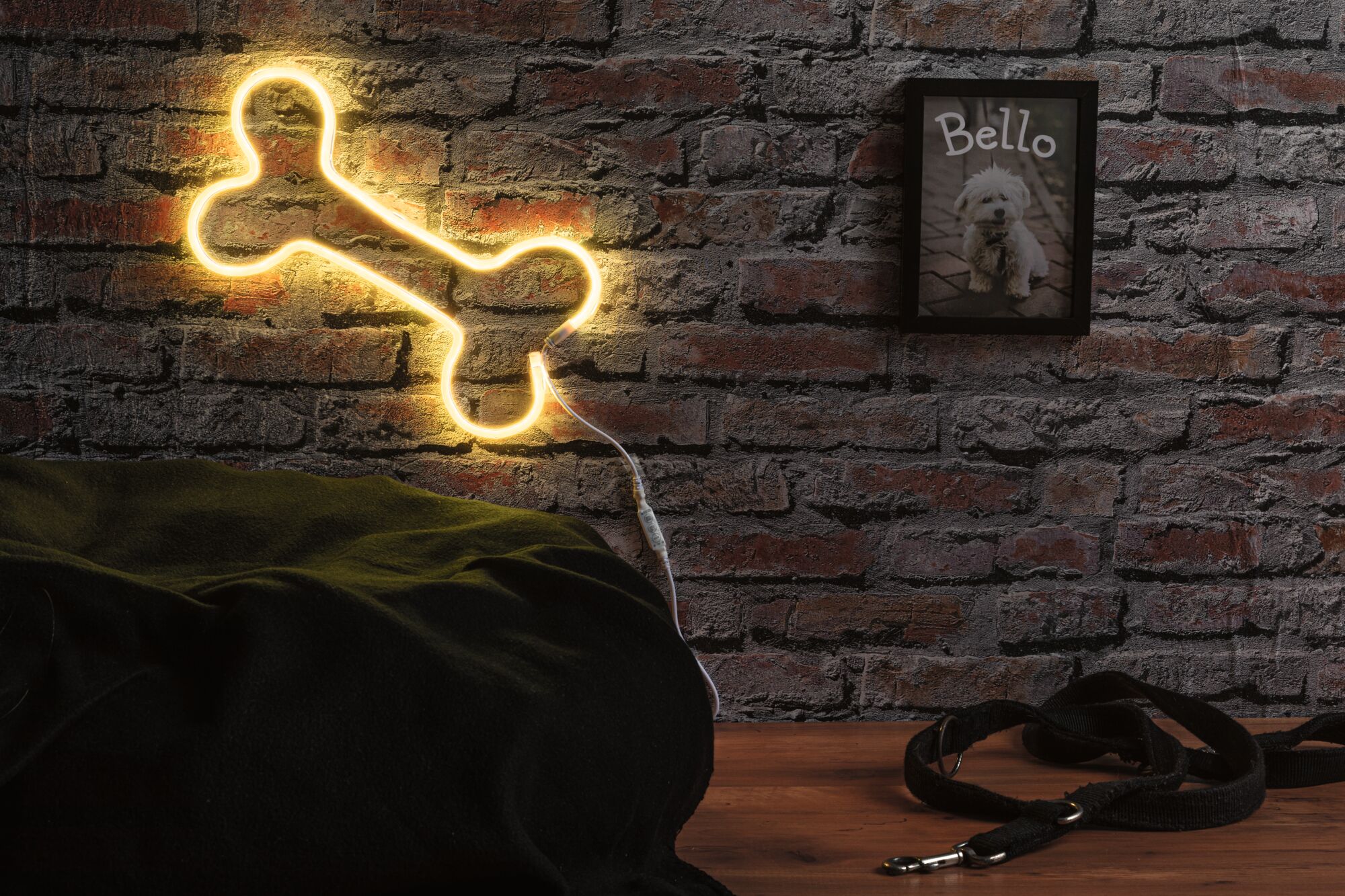 Lampe murale LED jaune en forme d'os en plastique sur mur en briques avec laisse de chien.