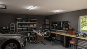Modern workshop with LED ceiling lights, bike on stand, tool wall, and workbench with storage units.