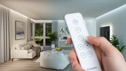 Hand hält weiße Fernbedienung mit Tasten für Lichtsteuerung in modernem Wohnzimmer mit indirekter Beleuchtung
