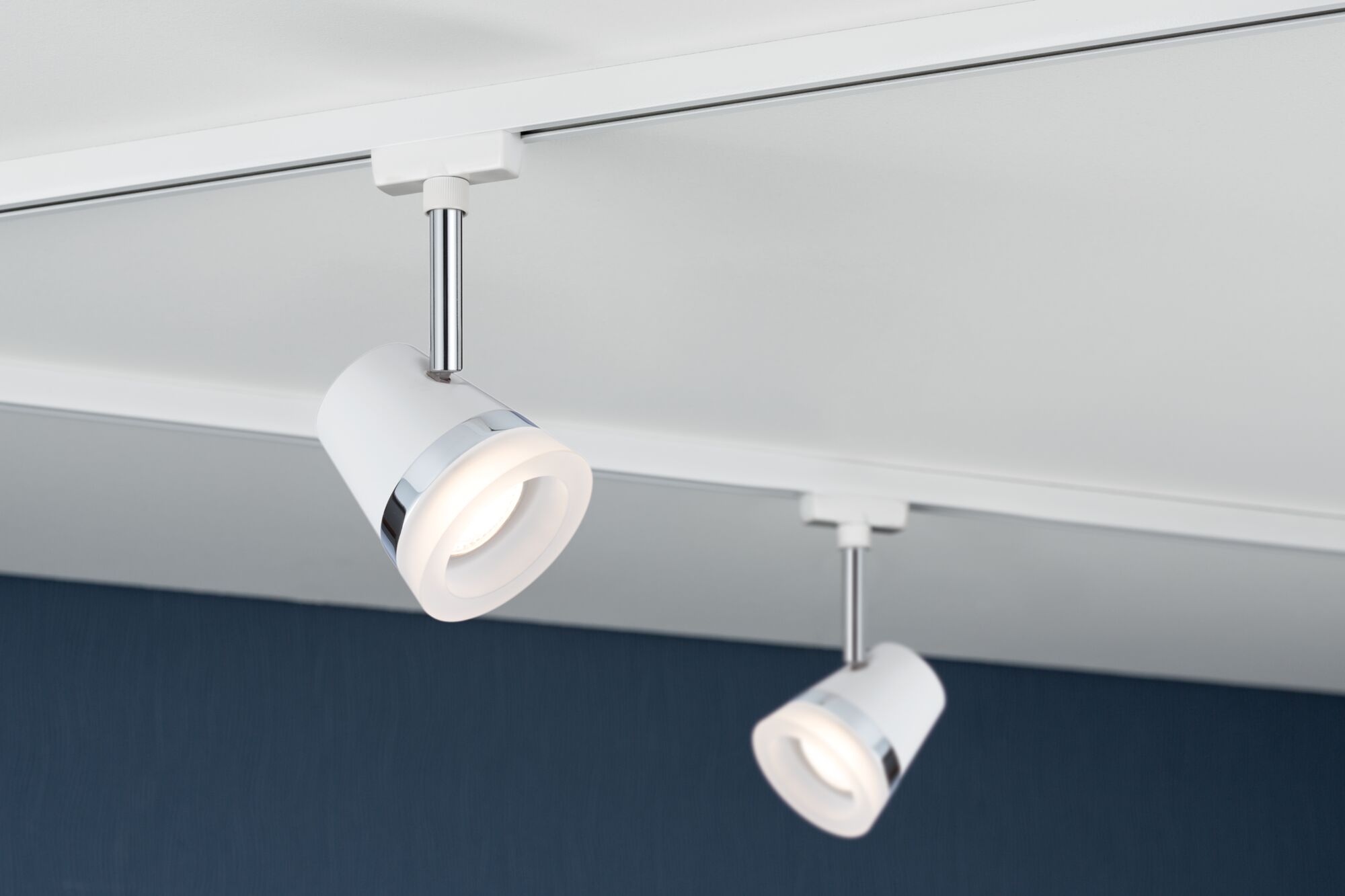Deux spots LED blancs avec anneau chromé fixés au plafond blanc pour éclairage moderne