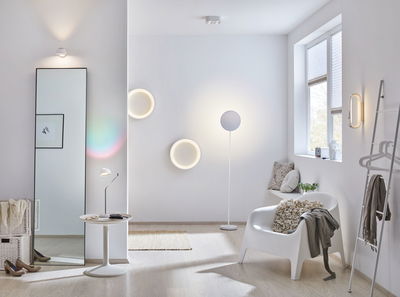 Salon moderne avec appliques murales LED blanches et lampe sur pied, design minimaliste avec sol en bois