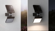 Black solar LED wall light with motion sensor shown day and night on white wall