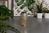 Metal lantern with intricate pattern casting warm light, decorative for indoor and outdoor use.