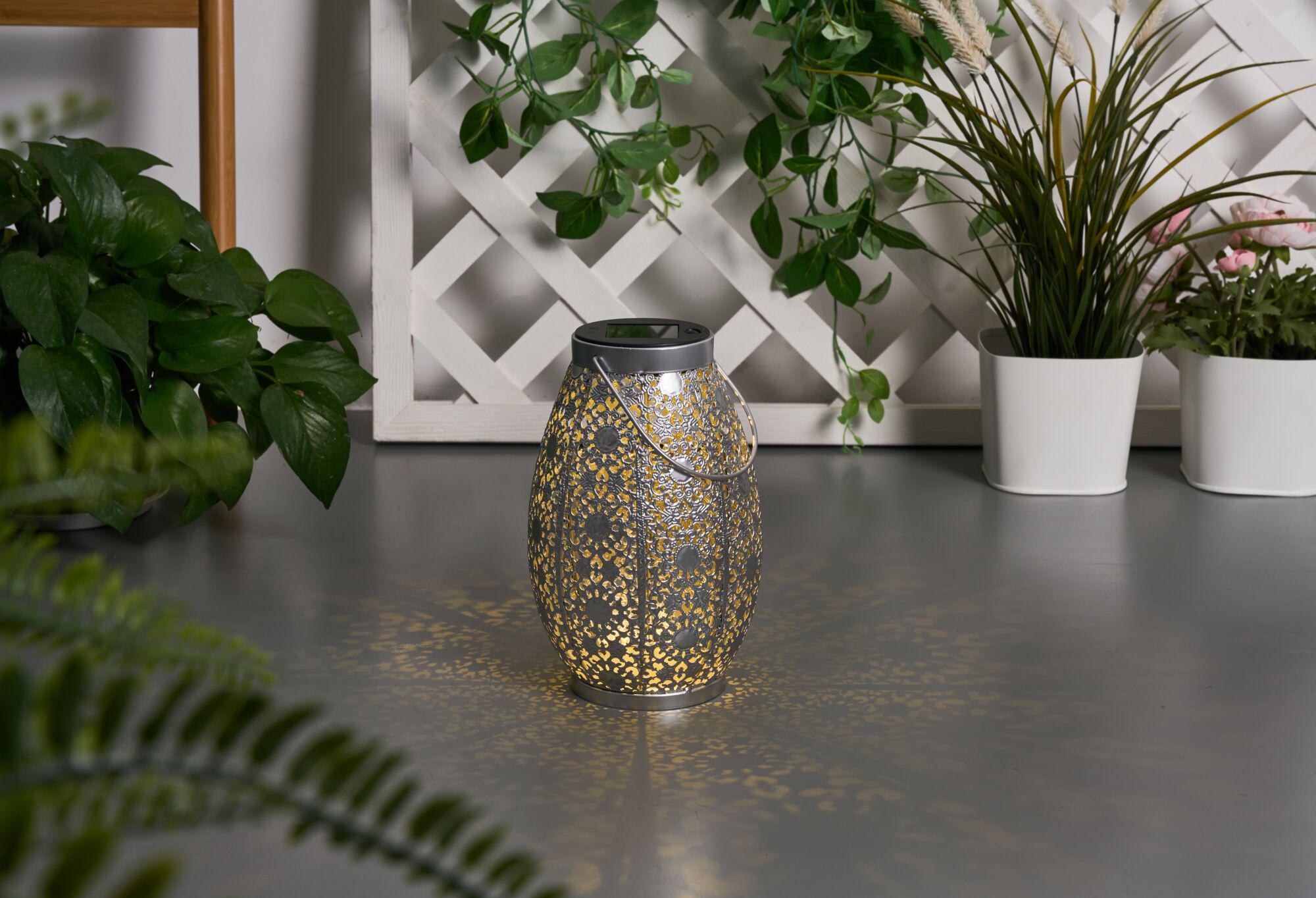Metal lantern with intricate pattern and warm light, decorative for garden or patio lighting