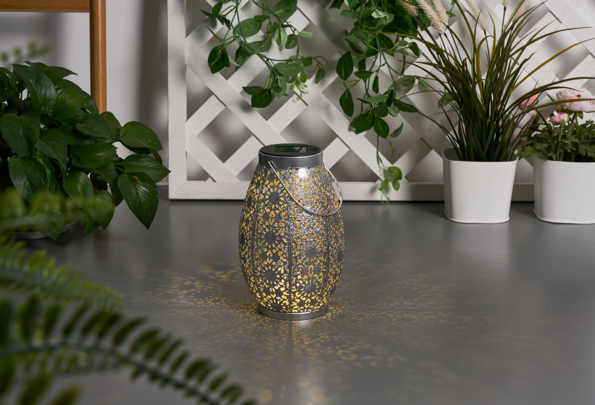 Metal lantern with intricate pattern and warm light, decorative for garden or patio lighting