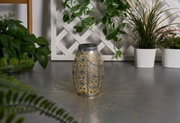 Metal lantern with intricate pattern and warm light, decorative for garden or patio lighting