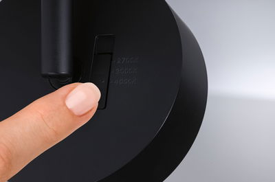 Vinger bedient zwarte schakelaar met kleurtemperatuuropties 2700K, 3000K, 4000K op lamp