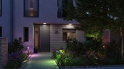 Modern house entrance with grey door and colorful LED garden lights for atmospheric outdoor lighting