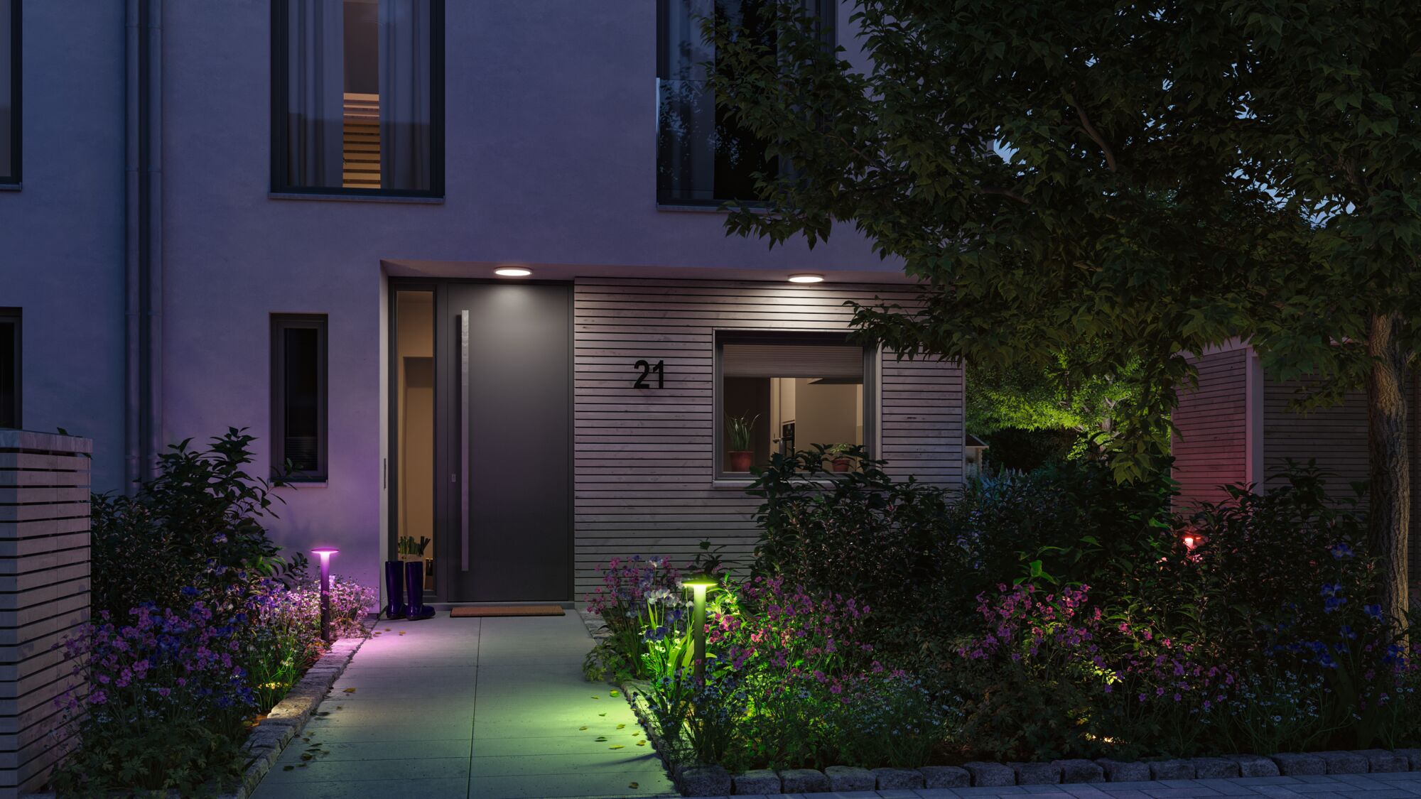 Modern house entrance with grey door and colorful LED garden lights for atmospheric outdoor lighting