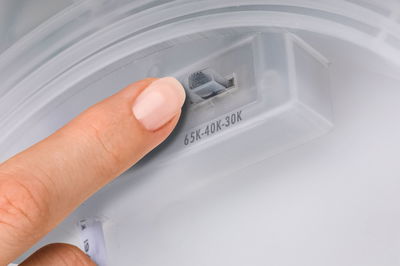 Finger stellt Farbtemperaturregler 65K-40K-30K an weißem Kunststofflichtgerät ein