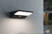 Schwarze LED-Außenwandleuchte aus Metall mit Bewegungsmelder an grauer Wand für Gartenbeleuchtung