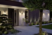 Moderne Außenwandleuchten in Schwarz an weißer Hausfassade mit Hausnummer 27 und Gartenbeleuchtung