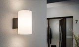Moderner Wandlampenschirm aus weißem Glas mit schwarzem Metallhalter für Innenbeleuchtung.