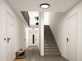 Rundes LED-Deckenlicht in Schwarz-Weiß in modernem Treppenhaus mit Betonboden und weißen Türen