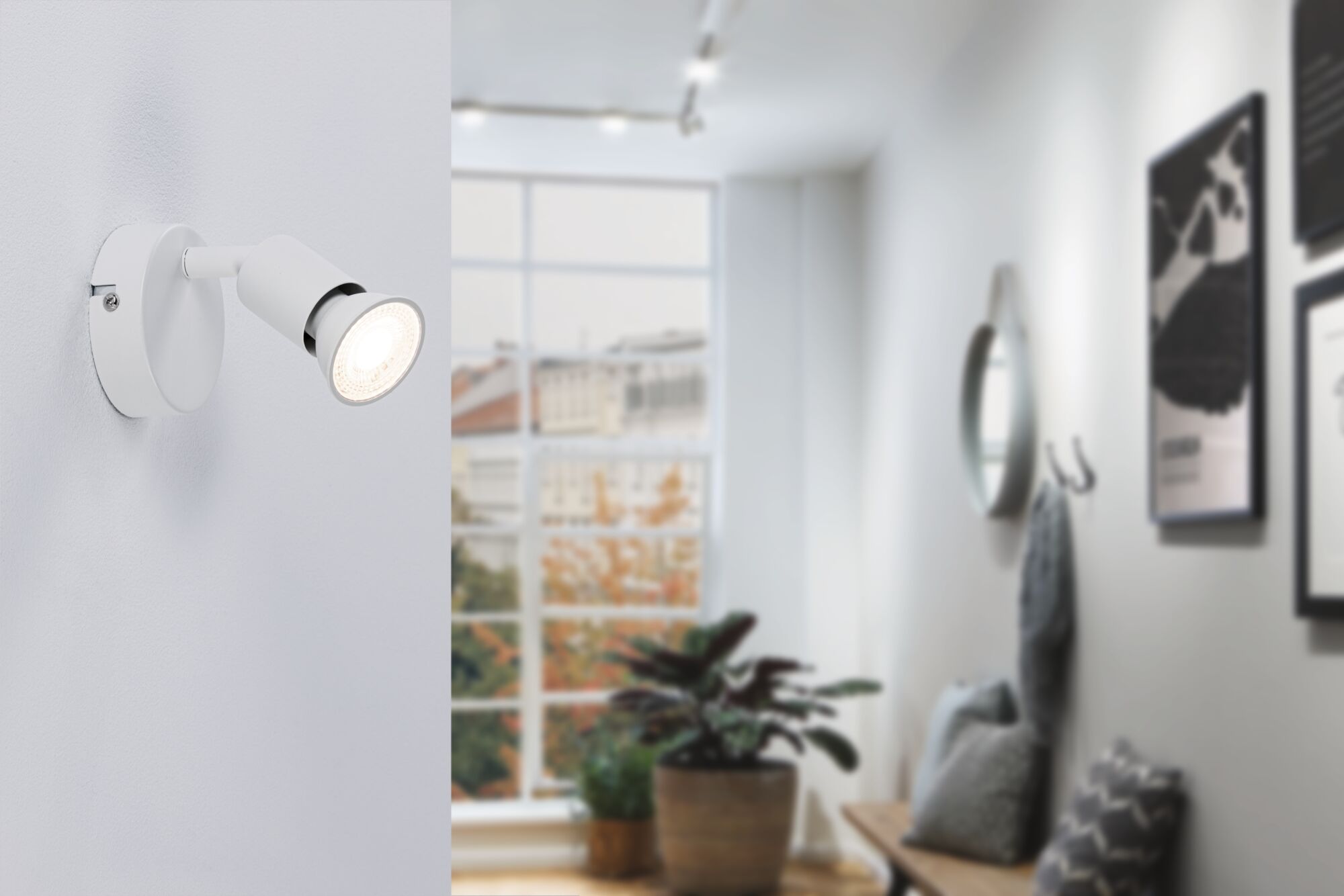Modern white metal LED wall spotlight in hallway with window and plants, indoor lighting